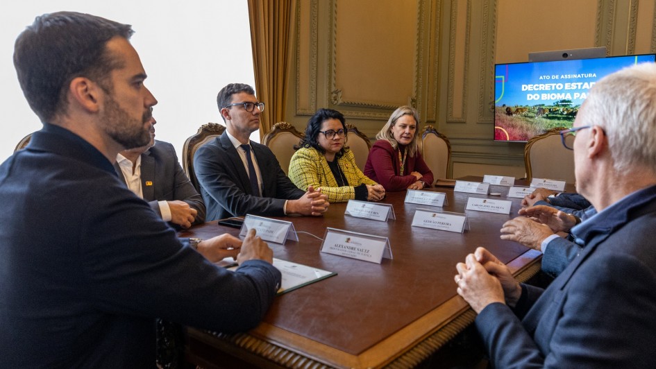 Diversas pessoas sentadas a uma mesa em reunião para assinatura do Decreto do Bioma Pampa